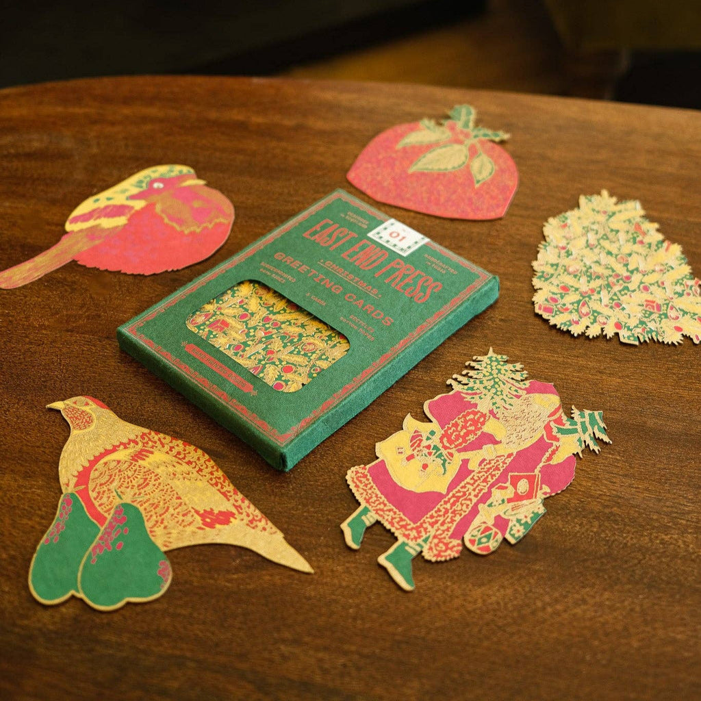 Decorative paper cutouts on a wooden surface with a green box labeled 'Eat the Rich'.