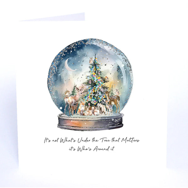 Christmas-themed snow globe with tree and reindeer, featuring a quote on a white background.