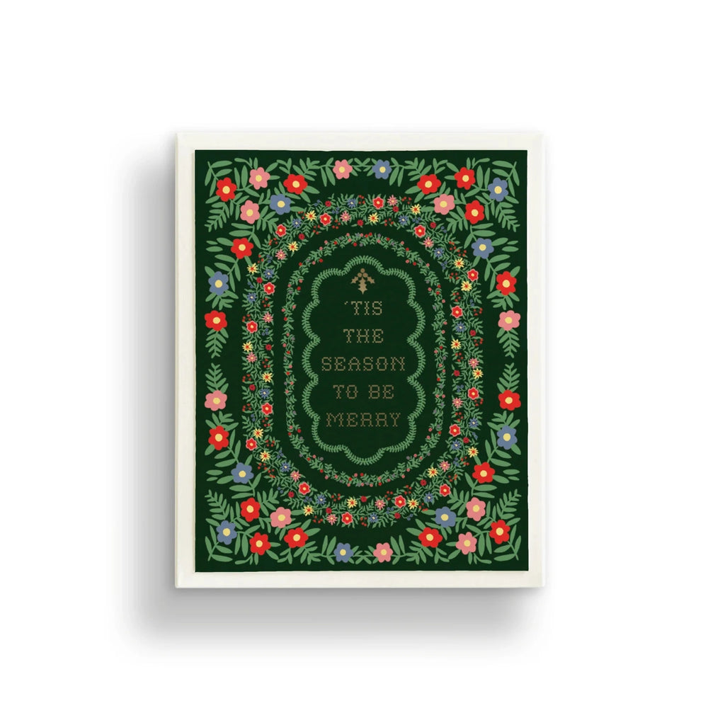 Framed artwork with floral border and text 'Tis the season to be merry' on a green background.