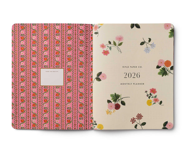 Two planners side by side, one with a pink floral pattern and the other with a beige cover featuring floral designs and the year 2026.