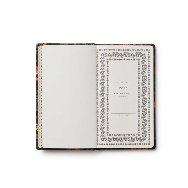 Open notebook with decorative cover and patterned pages on a white background