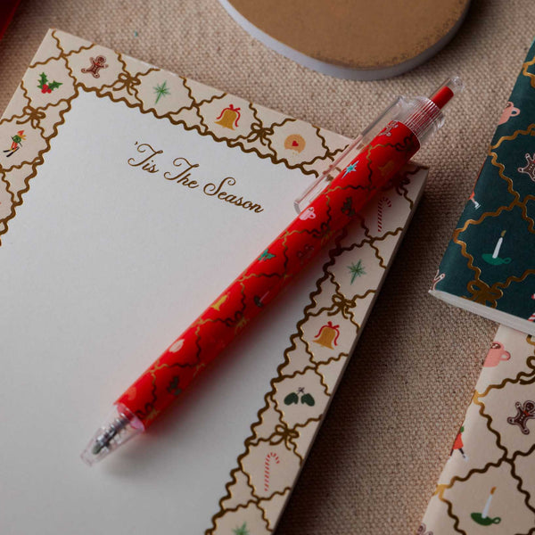 Red pen with Christmas design on a decorated card