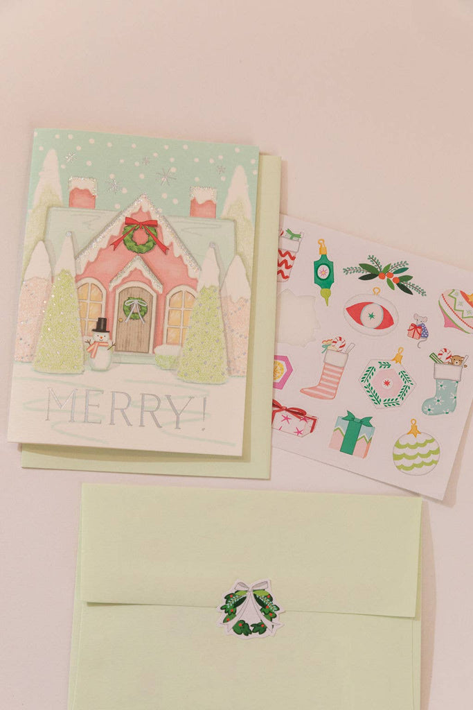 Christmas-themed card with envelope and additional cards on a light pink background