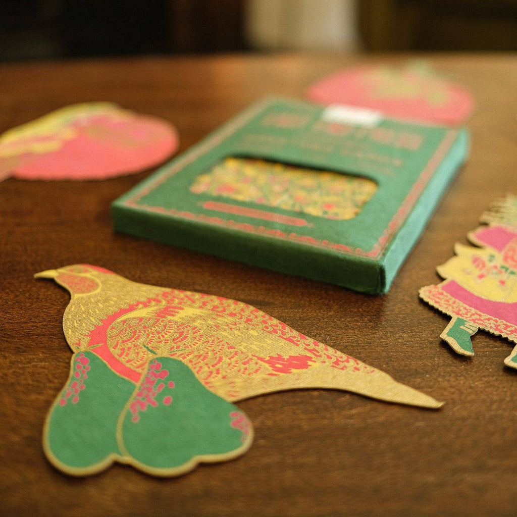 Colorful paper cutouts of birds on a wooden surface with a blurred background