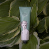 Tube of 'divine hand cream' by Alice Nava on a leafy background