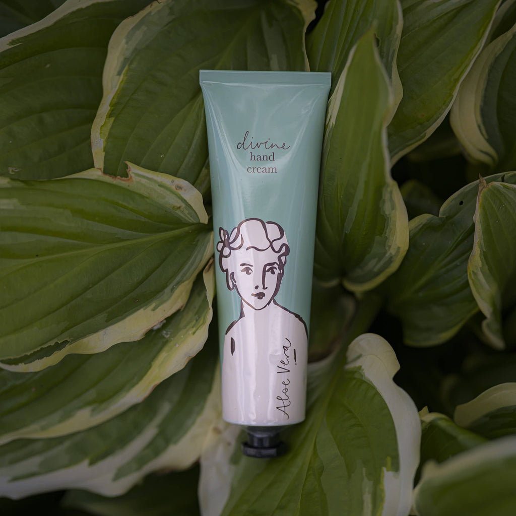 Tube of 'divine hand cream' by Alice Nava on a leafy background