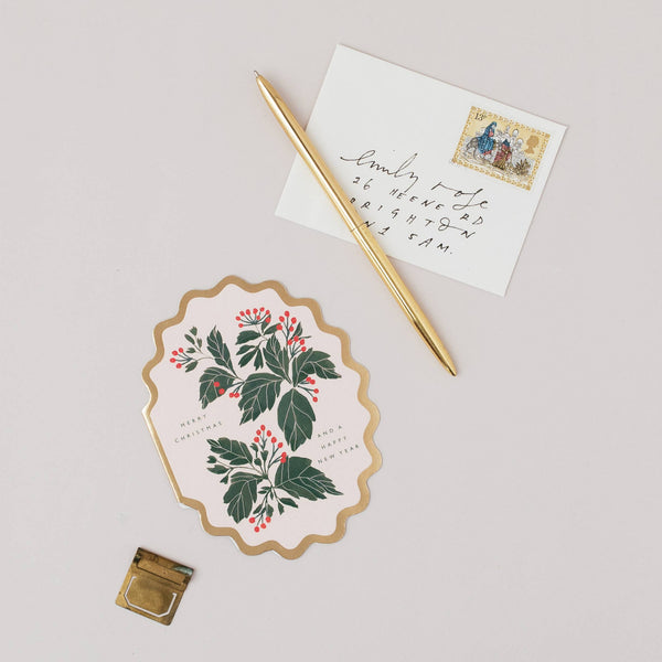 Decorative card with floral design, pen, and envelope on a light background
