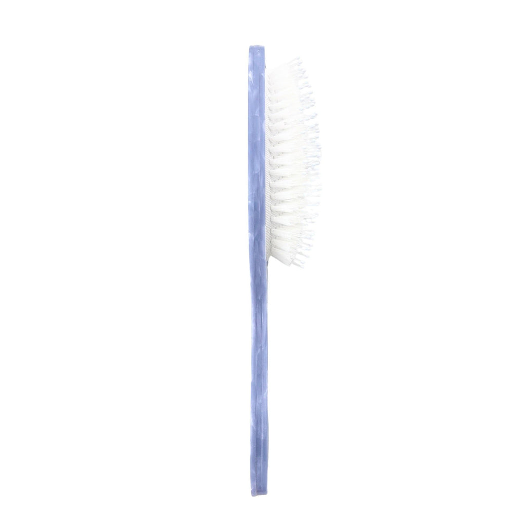 Cleaning brush with blue handle and white bristles on a white background