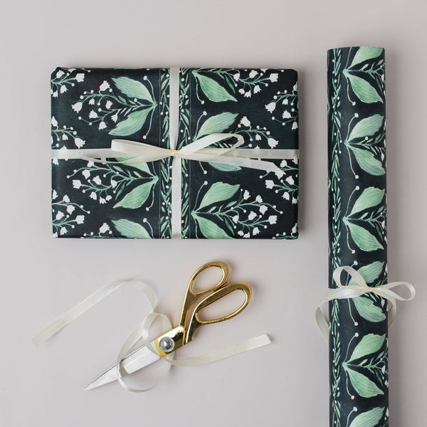 Floral-patterned gift wrap with scissors on a light gray background