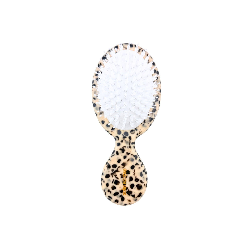 Hairbrush with leopard print handle on a white background