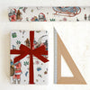 Christmas-themed gift wrap with Santa Claus design, a red ribbon, and a ruler on a white background.