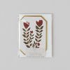 Floral design card with red flowers and green leaves on a white background