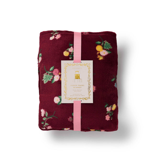 Floral-patterned blanket with a pink ribbon and tag on a white background