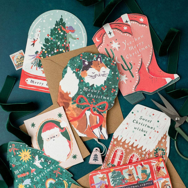 Collection of Christmas-themed greeting cards on a dark green background