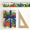 Christmas-themed wrapping paper with holly and berries, a wrapped gift with a blue ribbon, and a ruler on a white background.