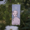 Box of divine hand cream with a woman's face on it, surrounded by greenery and flowers.