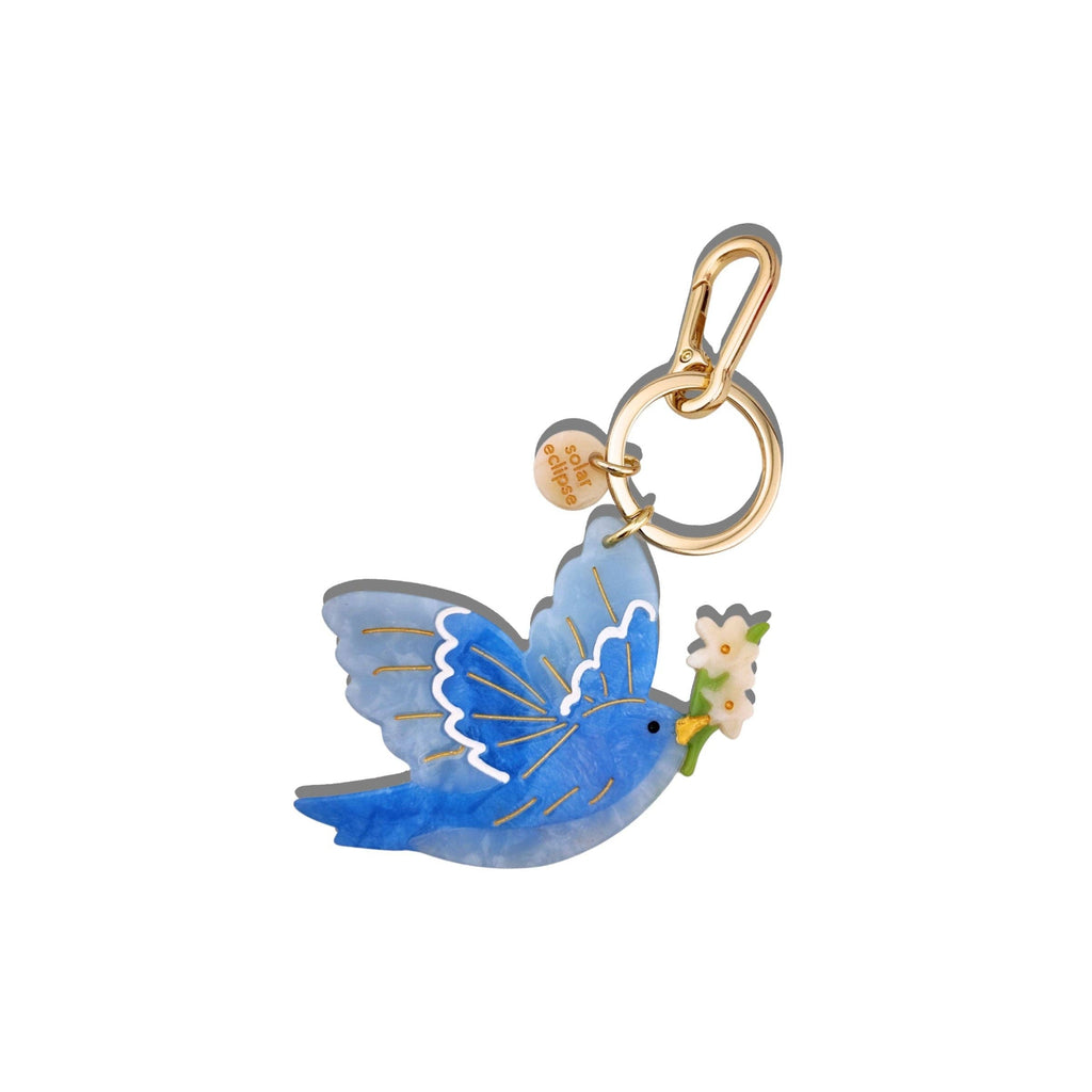 Blue butterfly charm with a gold ring on a white background