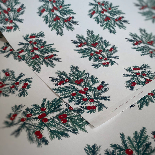 Christmas-themed paper with holly design on a white background