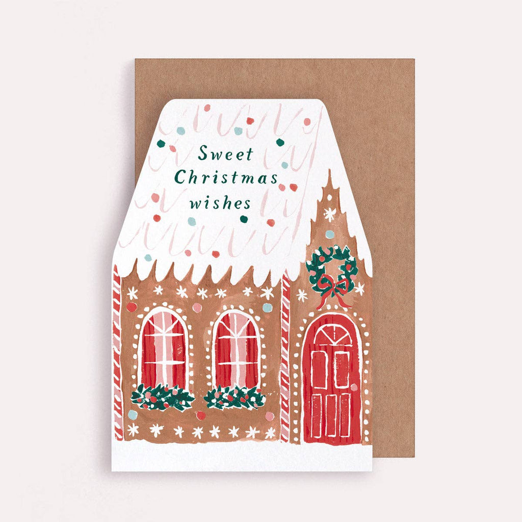 Greeting card with a gingerbread house design and 'Sweet Christmas wishes' text on a brown envelope.