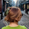 Person with a green sweater walking down a city street