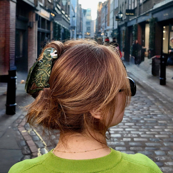 Person with a green sweater walking down a city street