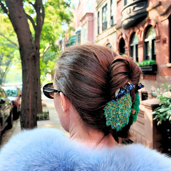 Person with styled hair and blue fur coat on a city street