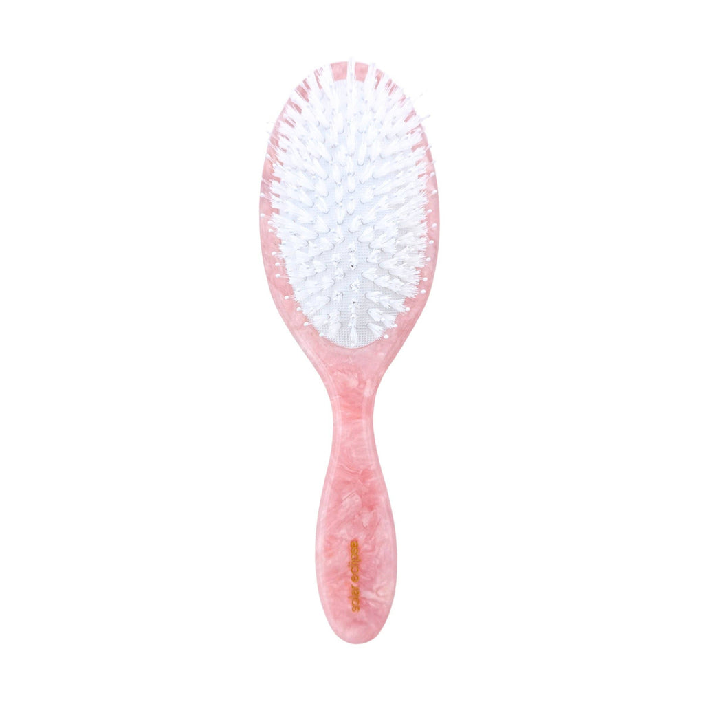 Pink hairbrush with white bristles on a white background