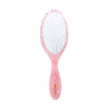Pink hairbrush with white bristles on a white background
