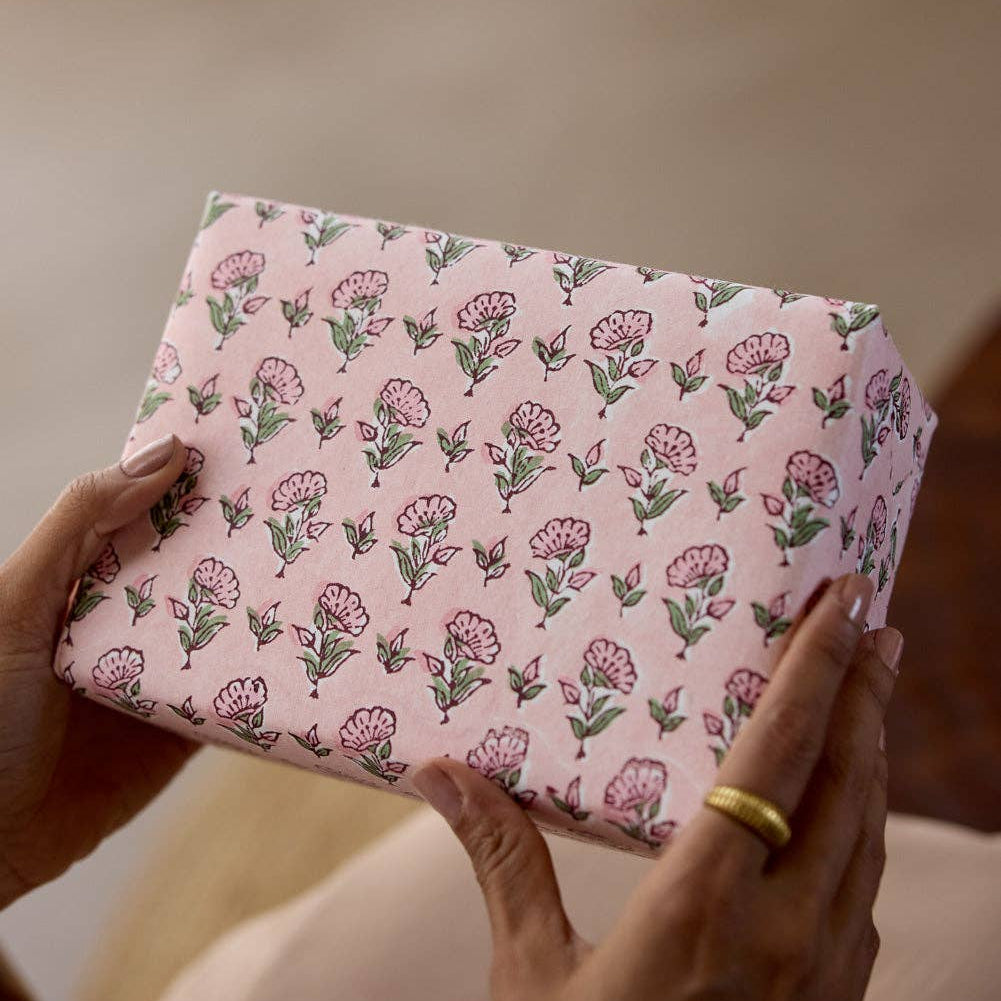 Person holding a pink floral-patterned box