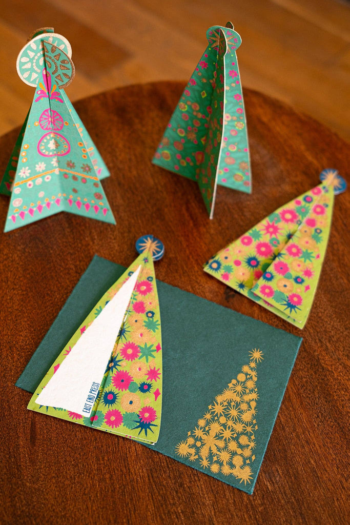 Colorful paper Christmas trees on a wooden surface