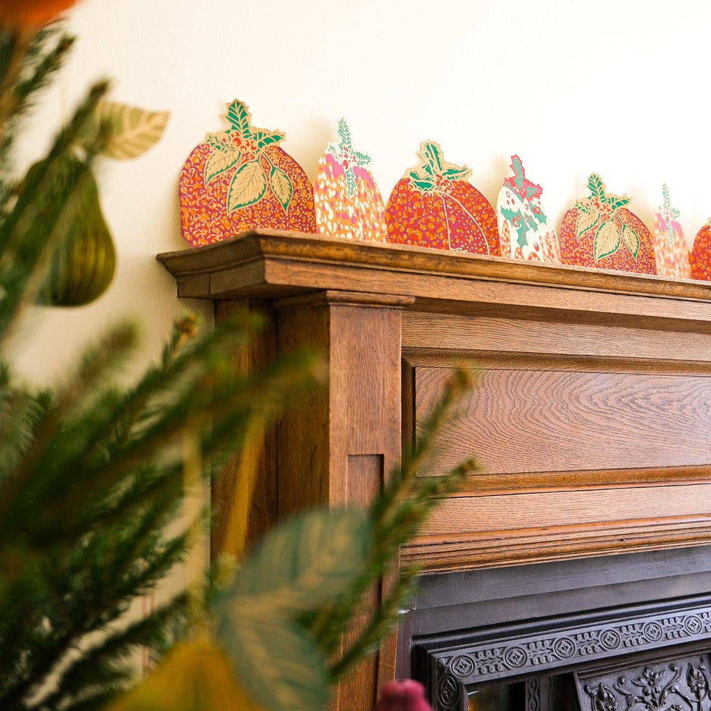 Decorative paper pumpkins on a mantelpiece with a blurred background