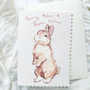 Greeting card with a bunny illustration and 'Bunny Kisses & Easter Wishes' text on a white textured background.