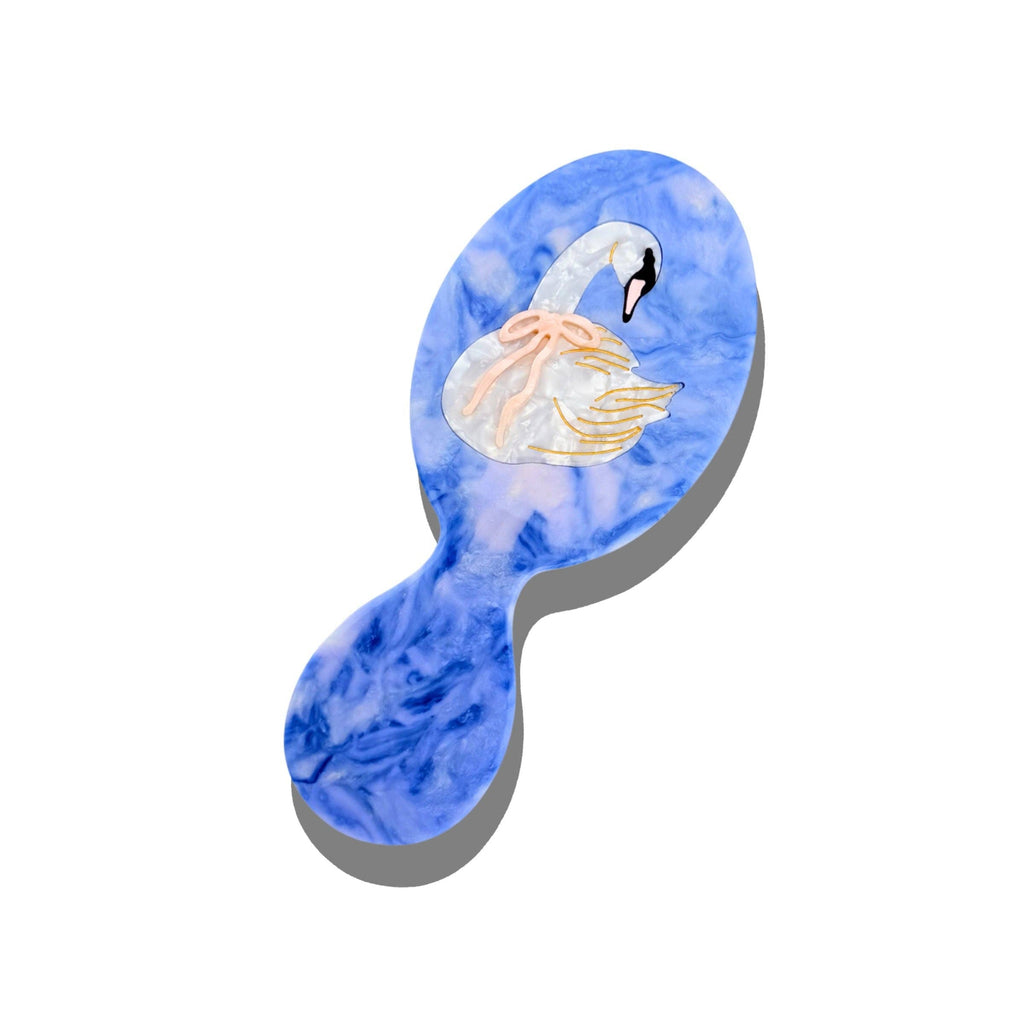 Hairbrush with a blue watercolor design of a swan on a white background
