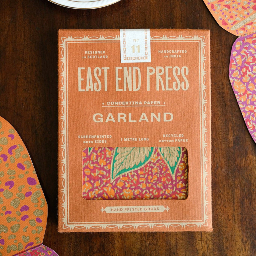 Box of East End Press Garland paper on a wooden surface with decorative paper pieces.