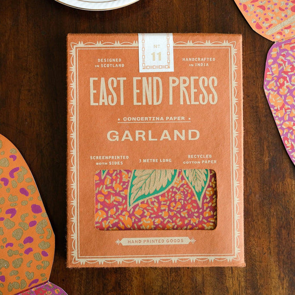 Box of East End Press Garland paper on a wooden surface with decorative paper pieces.