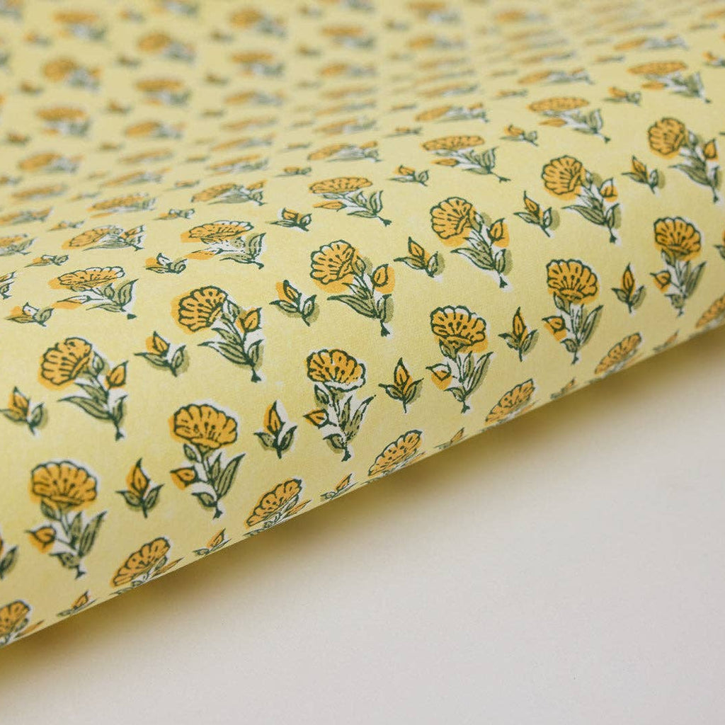 Roll of fabric with yellow floral pattern on a white background