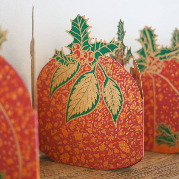 Decorative paper pumpkin with intricate leaf design on a wooden surface