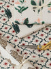 Floral and leaf-patterned wrapping paper with scissors on a matching background