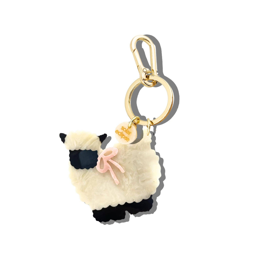 Llama-shaped keychain with a gold ring on a white background