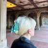 Person with a decorative hair clip standing in an ornate architectural setting