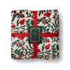 Floral-patterned blanket with red ribbons and a label on a white background