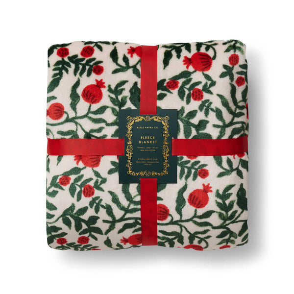 Floral-patterned blanket with red ribbons and a label on a white background