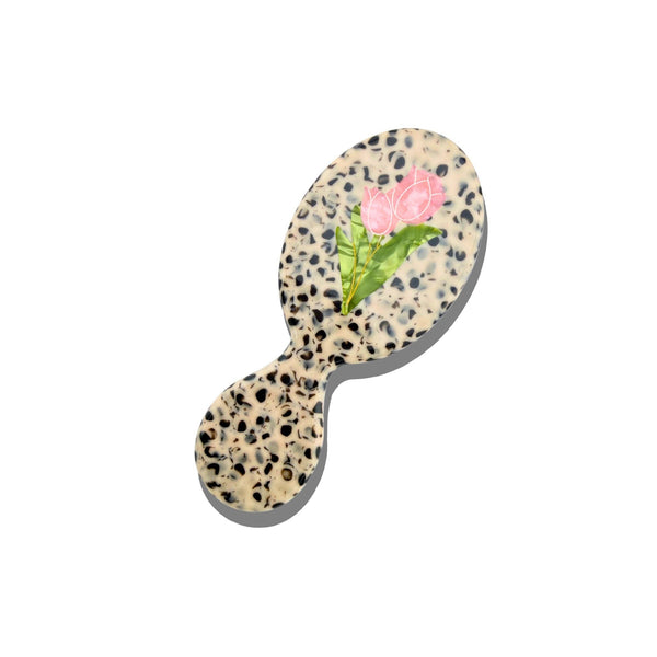 Small round brush with floral design on a white background