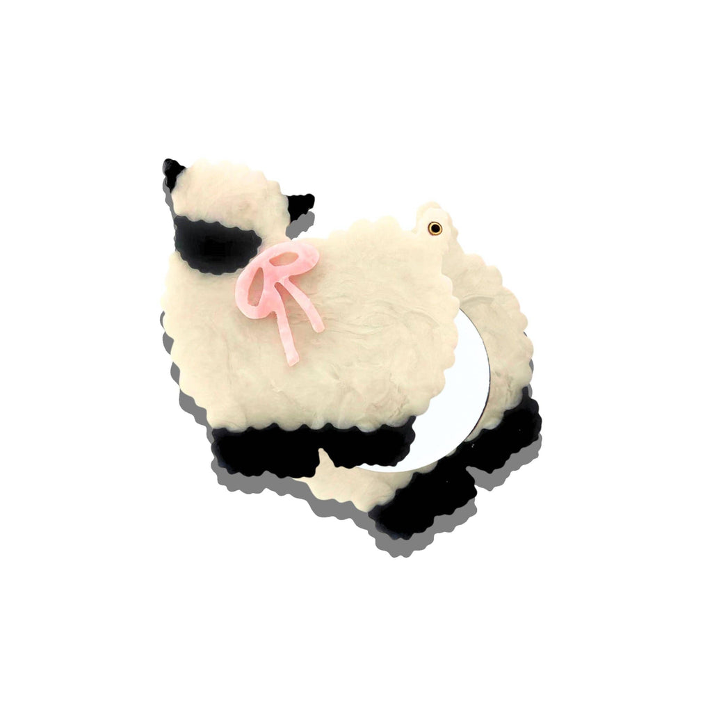 Plush toy resembling a cat with sunglasses and a bow on a white background