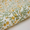 Roll of fabric with yellow floral pattern on a white background