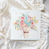 Card with floral design on a soft white fabric background