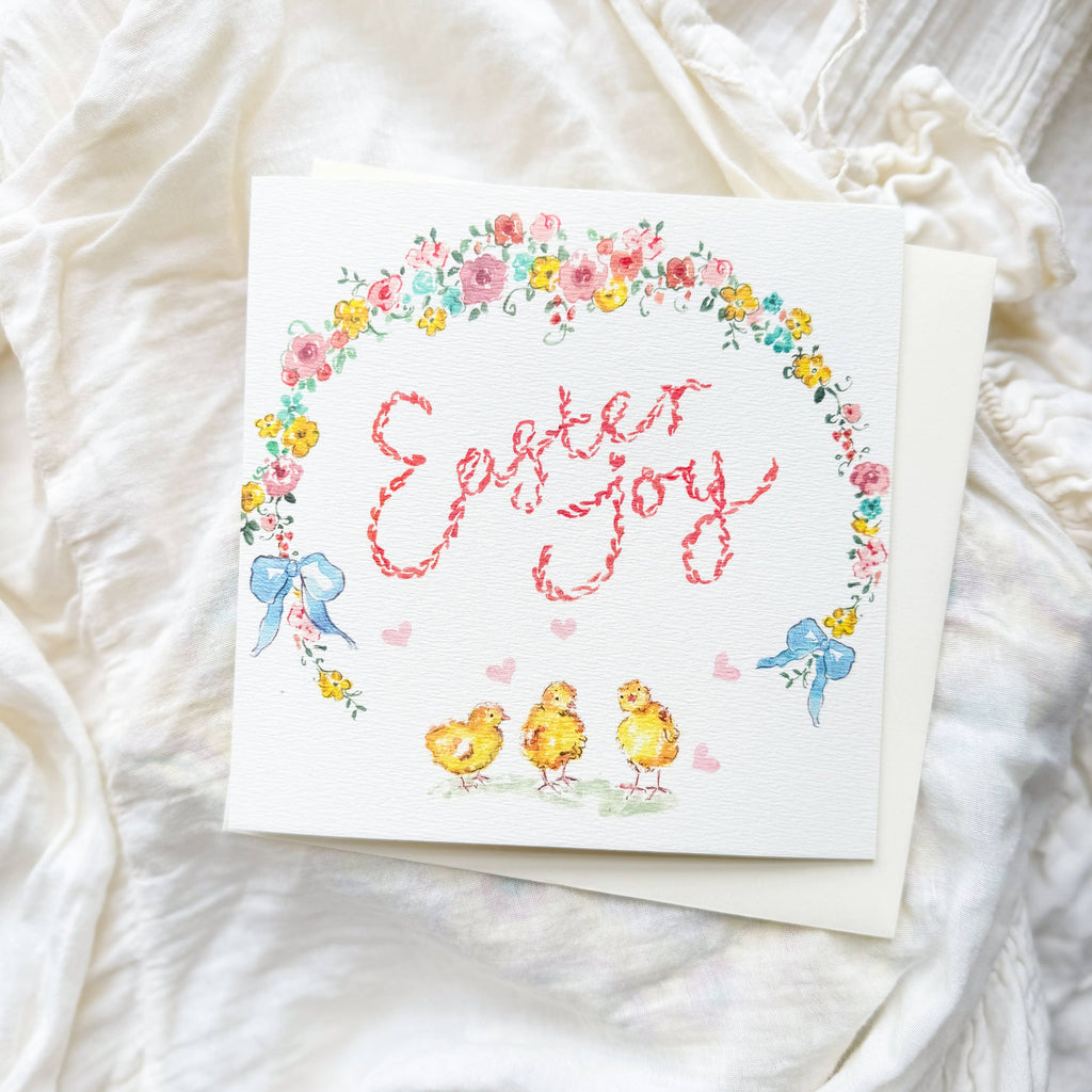 Card with 'Easter Joy' text and Easter-themed illustrations on a white fabric background
