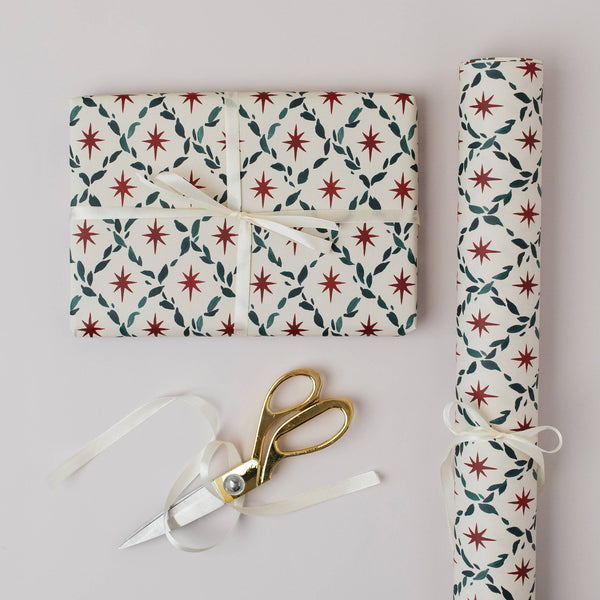 Gift wrapped in patterned paper with a pair of scissors on a light gray background