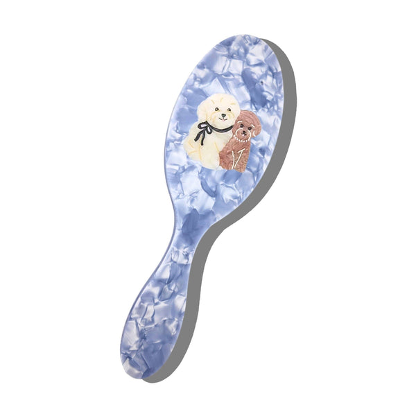 Hairbrush with dog illustrations on a blue floral patterned handle