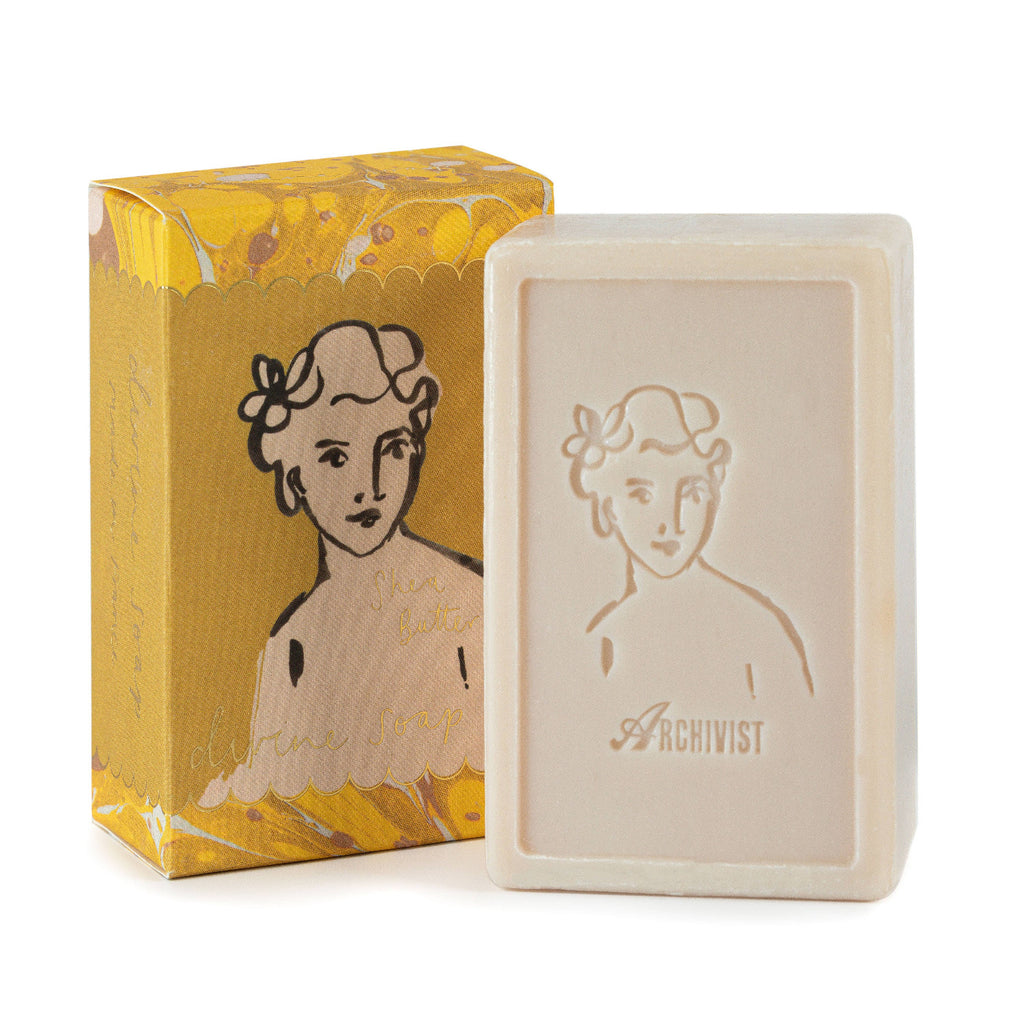 Bar of soap with embossed design and packaging featuring a woman's portrait on a white background